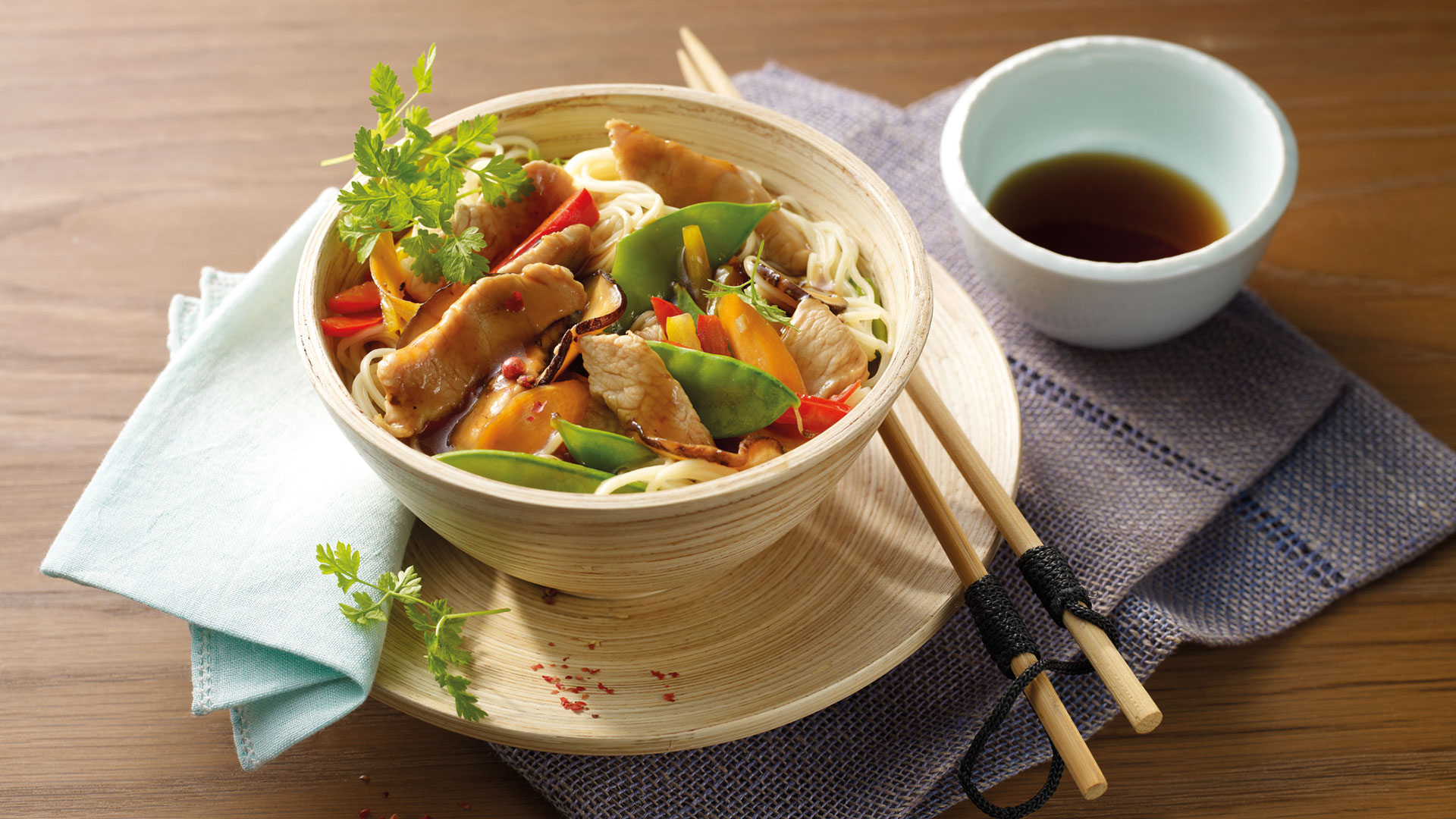 Putenfleisch aus dem Wok mit buntem Gemüse und Reis­nudeln ...